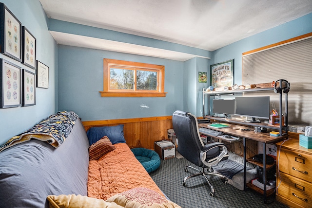 carpeted office space featuring wood walls