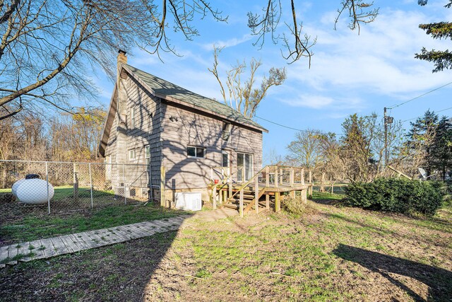 back of property featuring a lawn and a wooden deck