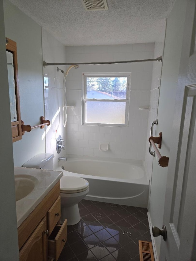 full bathroom with tile patterned floors, vanity, a textured ceiling, and tiled shower / bath