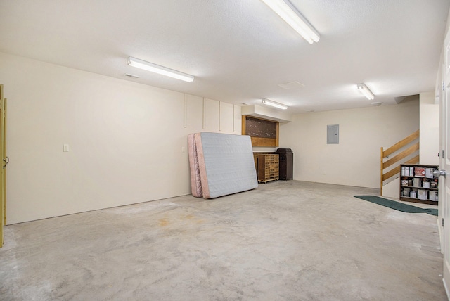 basement with a textured ceiling and electric panel