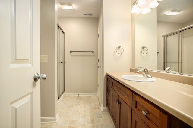 bathroom with vanity and a shower with shower door