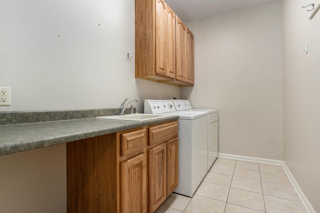 laundry room featuring washer and clothes dryer, light tile patterned flooring, cabinets, and sink