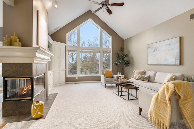 carpeted living room featuring ceiling fan, a fireplace, and high vaulted ceiling