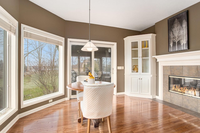 dining room featuring a fireplace, a healthy amount of sunlight, and light hardwood / wood-style flooring