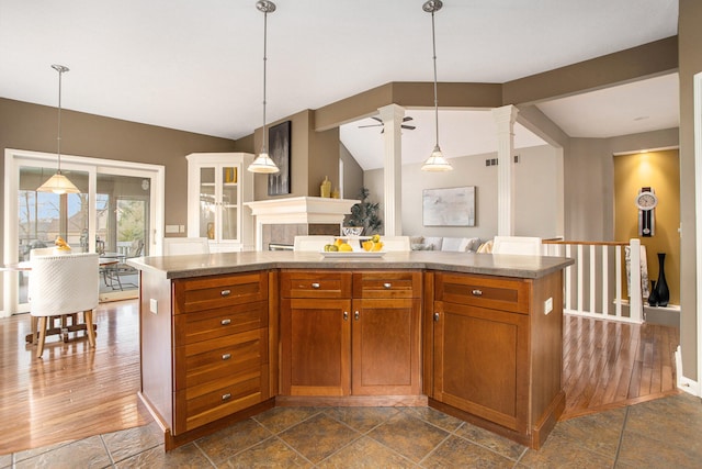 kitchen with pendant lighting, dark hardwood / wood-style floors, vaulted ceiling with beams, and a center island