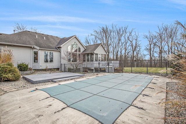 view of pool featuring a deck, a diving board, a patio area, and a sunroom