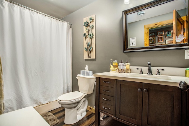 bathroom featuring wood-type flooring, vanity, and toilet