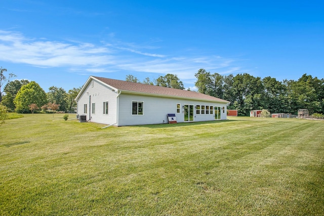 back of property with a lawn and cooling unit