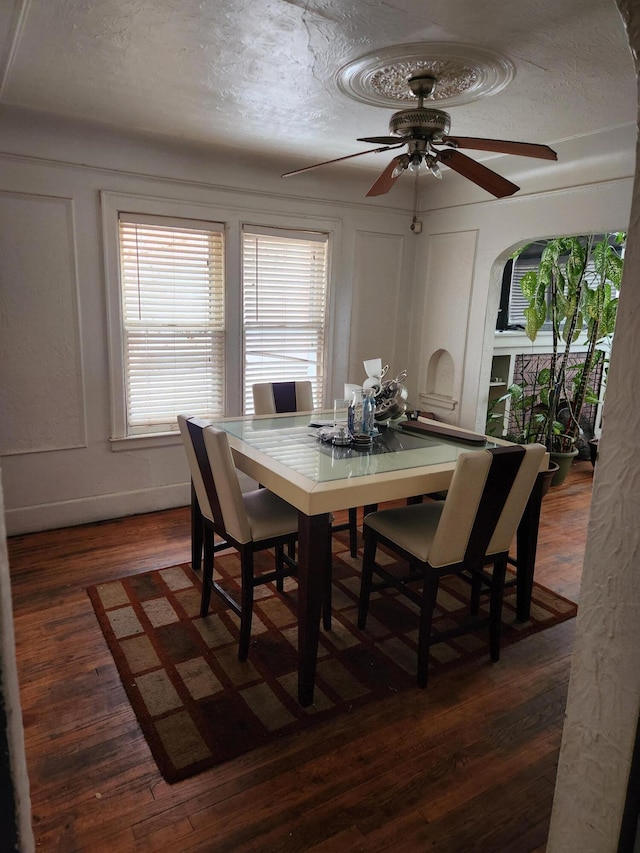 dining space featuring a textured ceiling, dark hardwood / wood-style floors, and ceiling fan