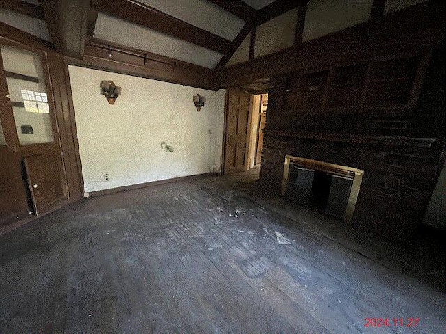 unfurnished living room with vaulted ceiling with beams