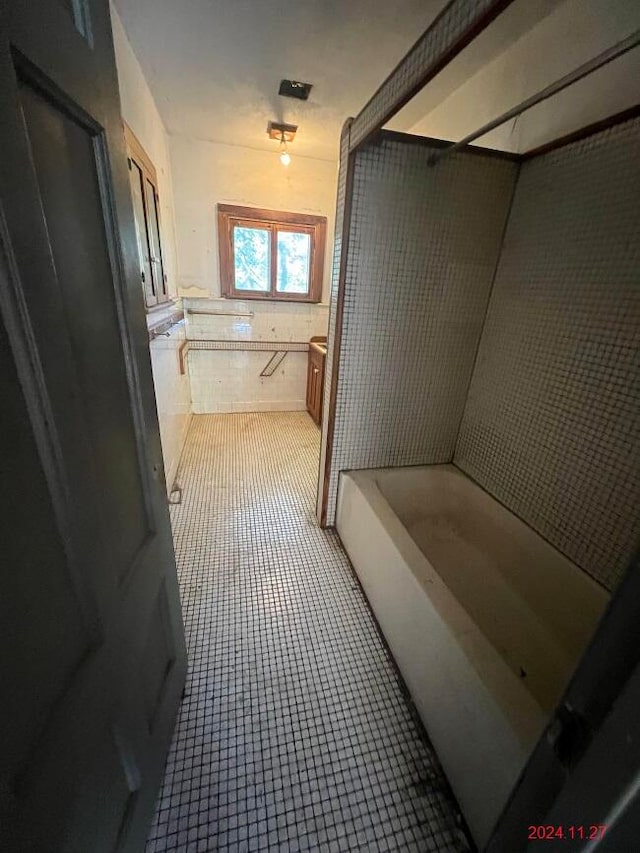 bathroom with tile patterned flooring, vanity, and tile walls