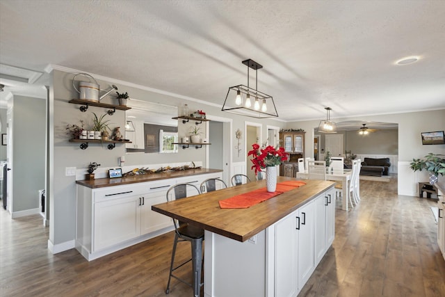 kitchen with white cabinets, wood counters, ceiling fan, and dark hardwood / wood-style flooring