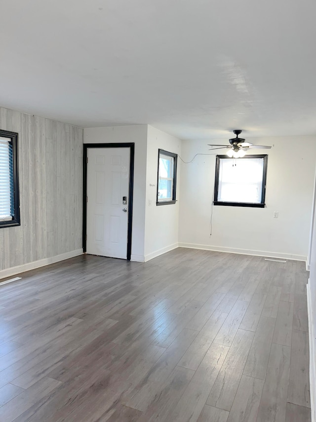 spare room with ceiling fan, wood finished floors, and baseboards