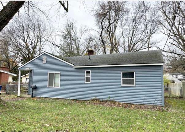 exterior space with a chimney, fence, and a yard