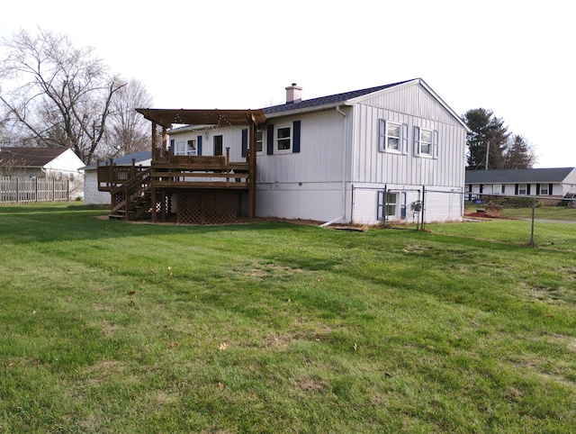 rear view of property with a deck and a lawn