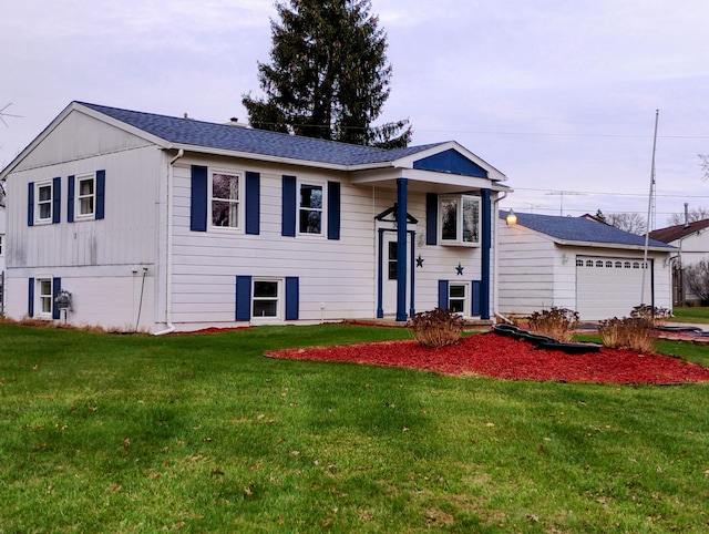 raised ranch featuring a garage and a front lawn