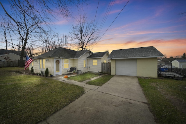 ranch-style home with a yard, an outbuilding, and a garage