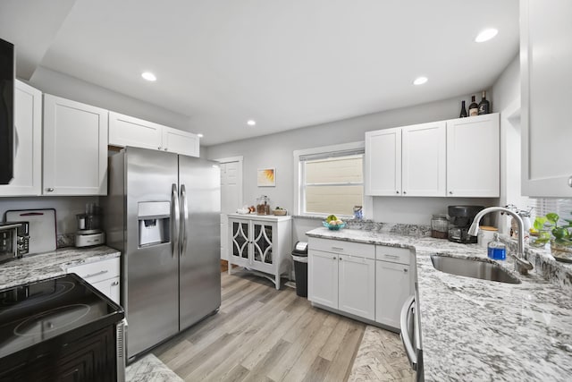 kitchen featuring white cabinets, stainless steel fridge with ice dispenser, range with electric cooktop, and light hardwood / wood-style flooring