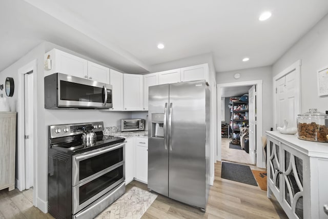 kitchen featuring white cabinets, appliances with stainless steel finishes, and light hardwood / wood-style flooring