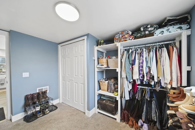 walk in closet with carpet