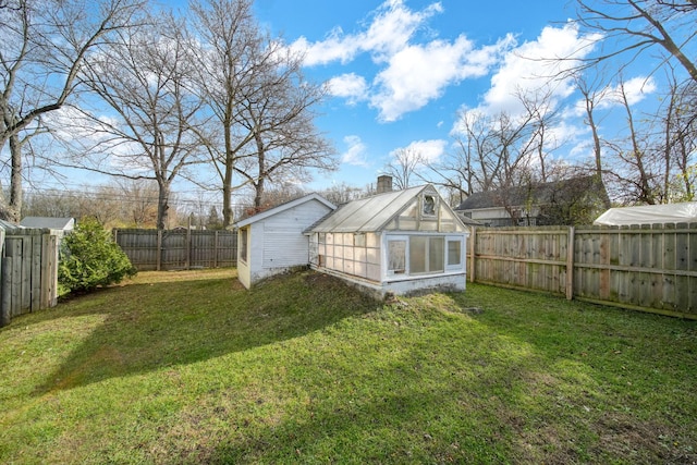 rear view of property with a lawn and an outbuilding