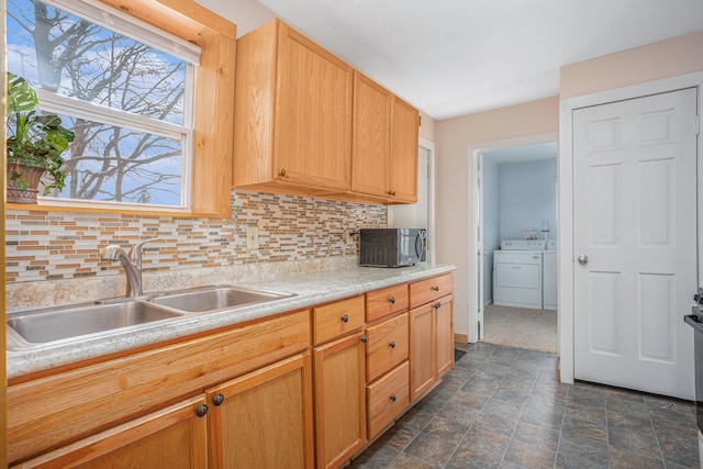 kitchen featuring decorative backsplash, independent washer and dryer, sink, and light brown cabinetry