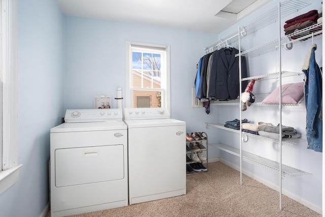 clothes washing area with independent washer and dryer and light carpet