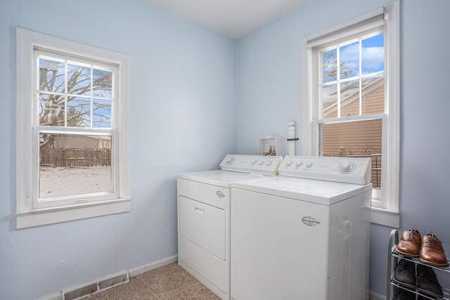 washroom featuring washing machine and dryer, a wealth of natural light, and carpet floors