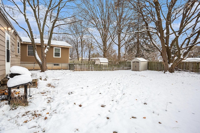 yard covered in snow with a storage unit