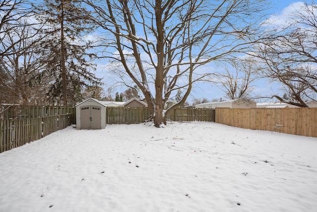 yard layered in snow featuring a storage unit