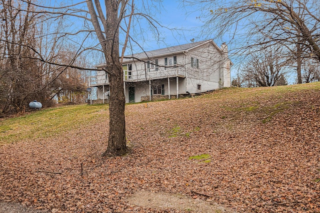 back of property featuring a lawn and a wooden deck