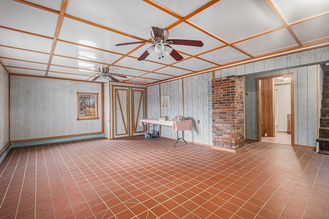 basement featuring ceiling fan, baseboard heating, and wooden walls