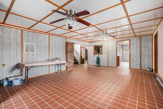 basement with tile patterned floors, ceiling fan, and wooden walls