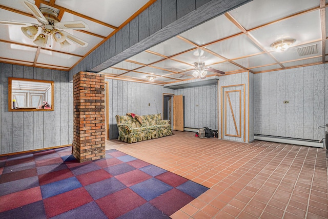 basement featuring tile patterned floors, ceiling fan, wooden walls, and a baseboard heating unit