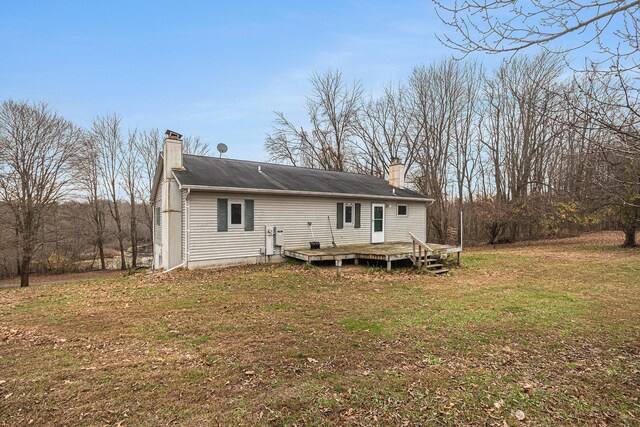 rear view of house featuring a yard and a deck