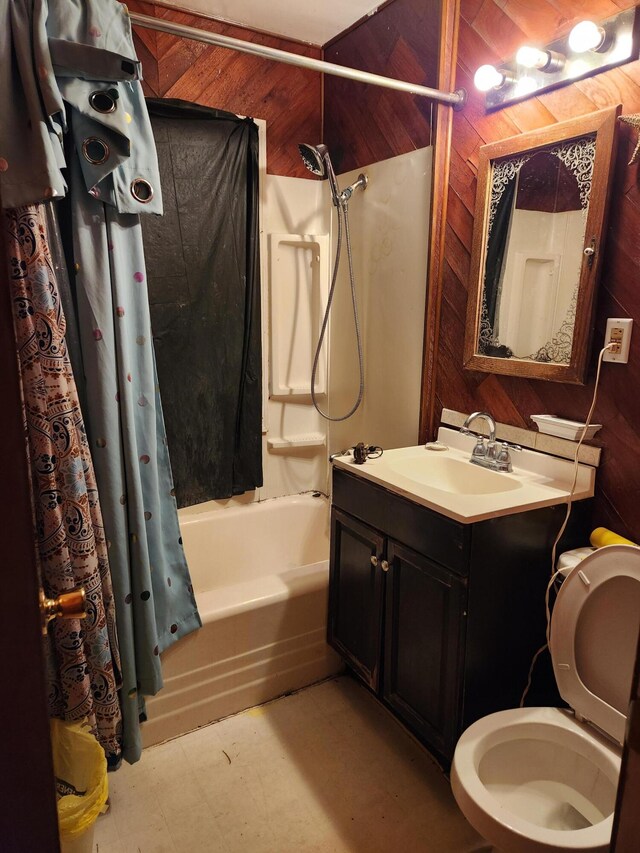 full bathroom featuring wooden walls, vanity, shower / bath combo, and toilet