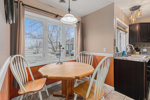 tiled dining room featuring sink