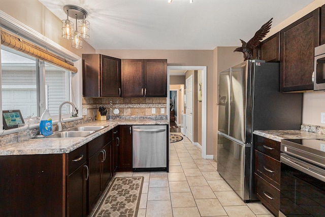 kitchen with sink, decorative light fixtures, light tile patterned floors, dark brown cabinets, and stainless steel appliances