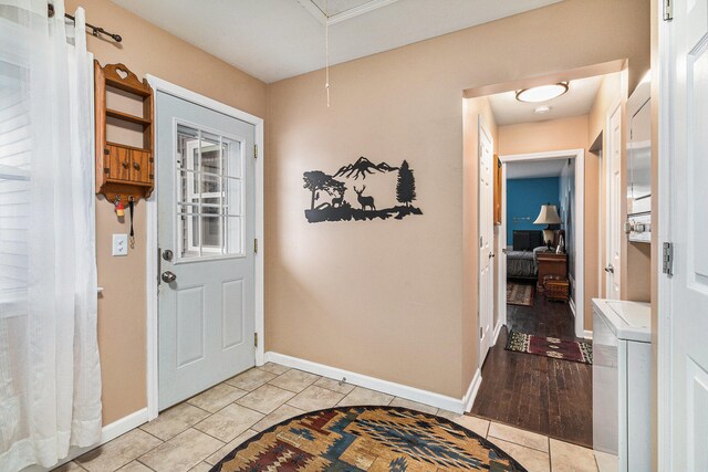 foyer entrance with washer / dryer and light wood-type flooring