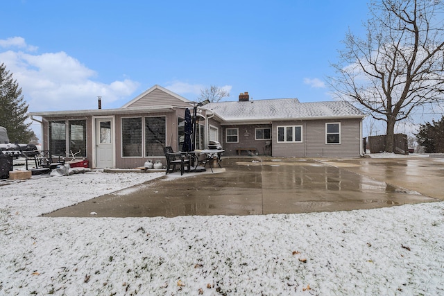 view of snow covered back of property