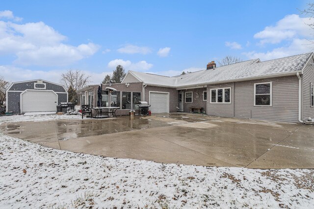 snow covered house featuring a garage