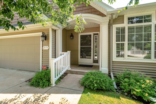 view of exterior entry featuring covered porch and a garage