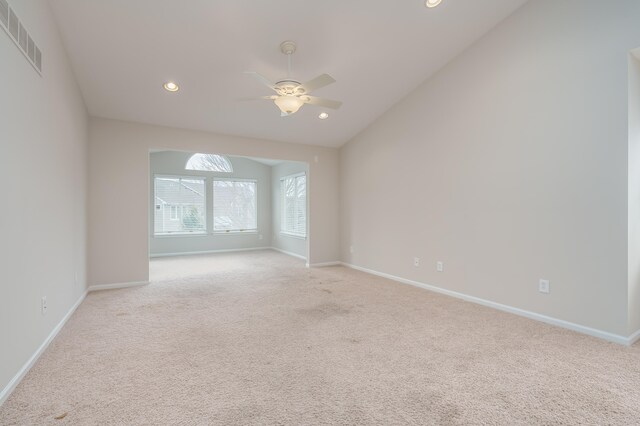 carpeted spare room with ceiling fan and lofted ceiling