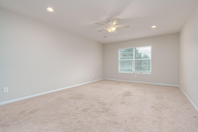 carpeted spare room featuring ceiling fan