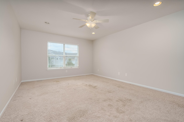 carpeted spare room featuring ceiling fan