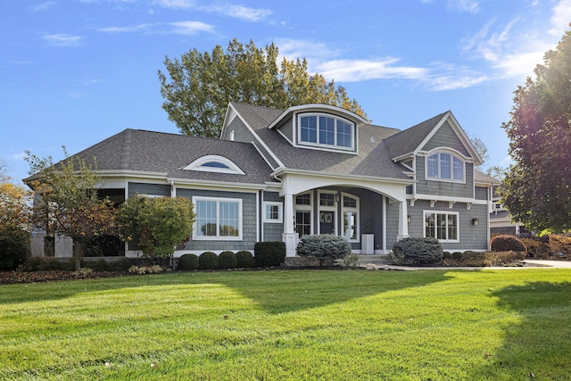 view of front of property featuring a shingled roof and a front yard