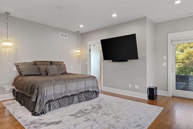 bedroom with recessed lighting, wood finished floors, visible vents, baseboards, and access to outside