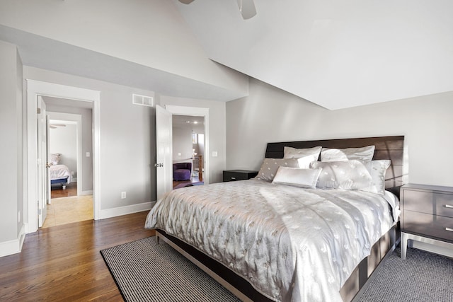 bedroom with baseboards, visible vents, a ceiling fan, wood finished floors, and vaulted ceiling