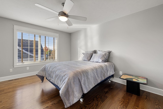 bedroom featuring visible vents, ceiling fan, baseboards, and wood finished floors