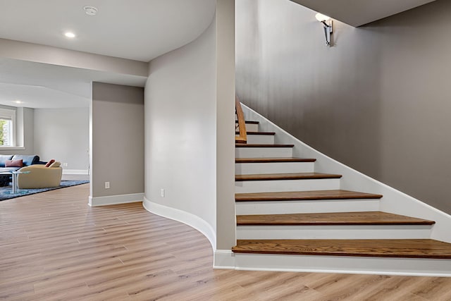 stairway featuring recessed lighting, wood finished floors, and baseboards